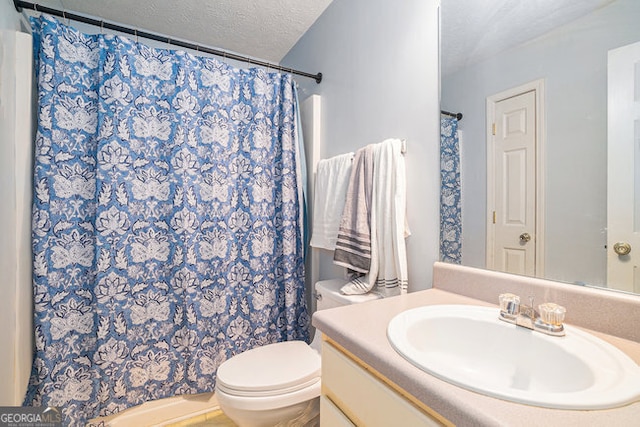 bathroom featuring a textured ceiling, toilet, vanity, and walk in shower