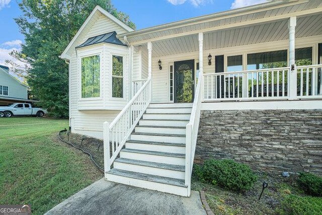 view of front of home with a front yard and a porch