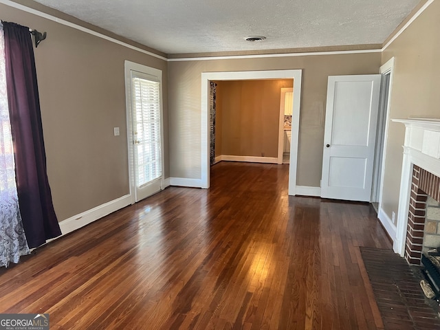 unfurnished living room with a brick fireplace, a textured ceiling, crown molding, and dark wood-type flooring