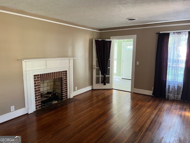 unfurnished living room with ornamental molding, a brick fireplace, a textured ceiling, and dark hardwood / wood-style floors