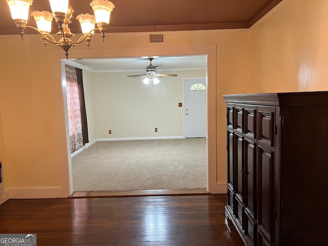 interior space featuring ceiling fan with notable chandelier, ornamental molding, and dark hardwood / wood-style flooring