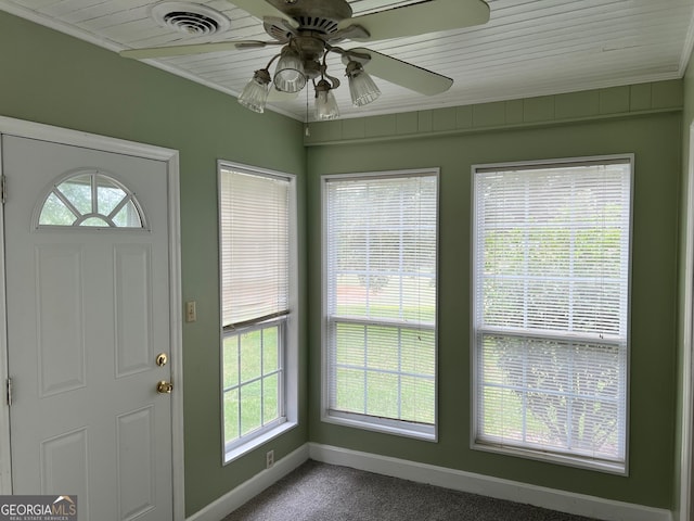 foyer entrance featuring ceiling fan, carpet floors, and crown molding