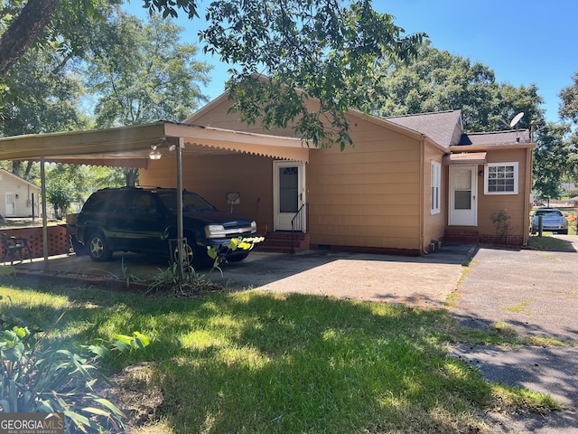 view of front facade featuring a front yard and a carport