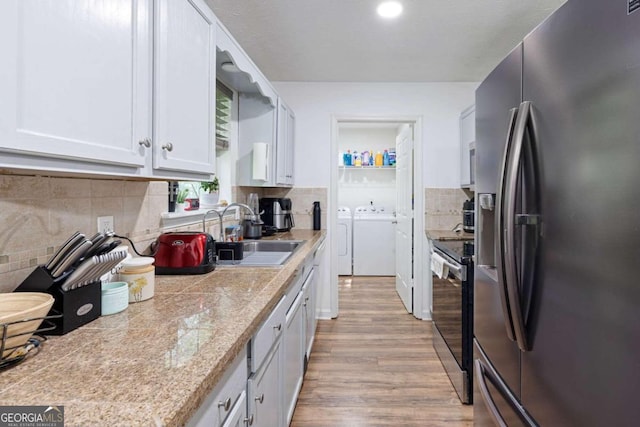 kitchen with tasteful backsplash, white cabinetry, light hardwood / wood-style flooring, and appliances with stainless steel finishes