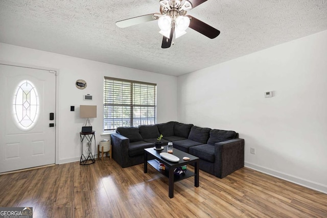 living room featuring a textured ceiling, ceiling fan, and hardwood / wood-style flooring