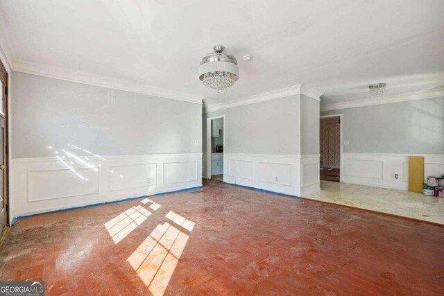 tiled spare room featuring crown molding