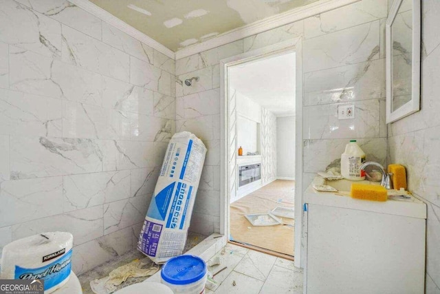 bathroom with tile patterned flooring, tile walls, crown molding, and walk in shower