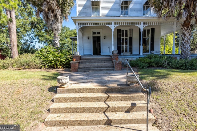 view of front of property featuring covered porch and a front yard