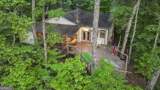 back of property featuring a deck, roof with shingles, and stairs