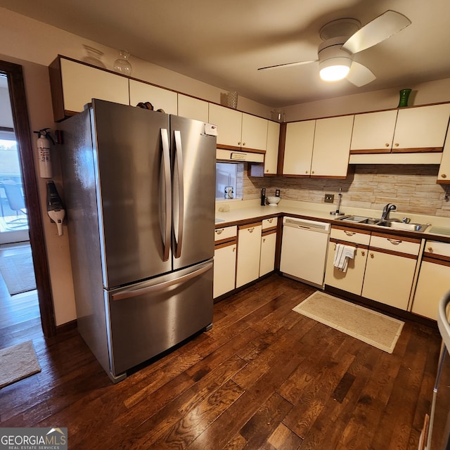 kitchen featuring dark wood-type flooring, white dishwasher, sink, white cabinetry, and stainless steel refrigerator