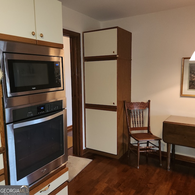 kitchen featuring appliances with stainless steel finishes, dark hardwood / wood-style floors, and white cabinetry