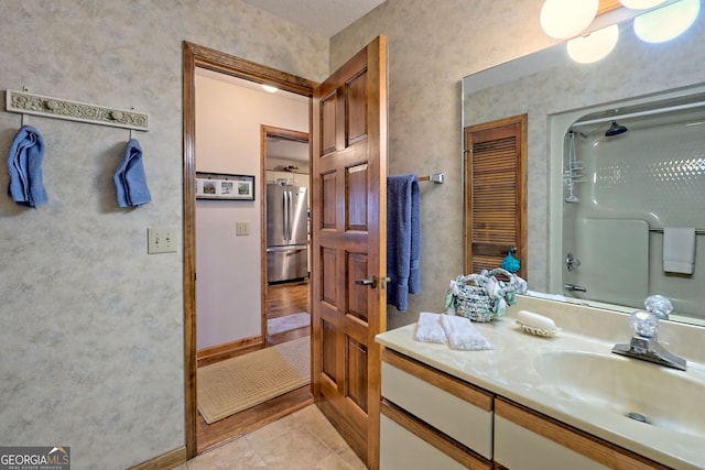 bathroom featuring vanity, a shower, and tile patterned floors