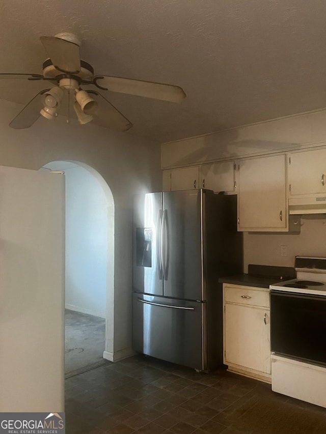 kitchen featuring stainless steel fridge, white range with electric cooktop, white cabinetry, and ceiling fan