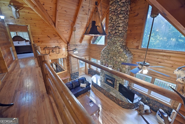 living room with wooden walls, beam ceiling, hardwood / wood-style floors, and wooden ceiling