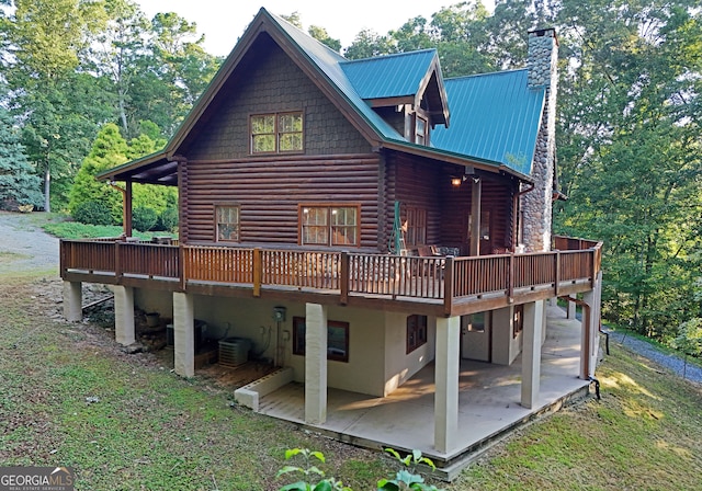 back of house with a deck and a patio