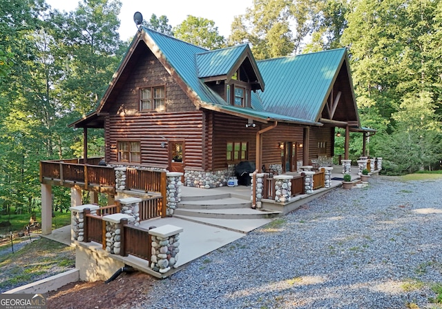 back of property featuring a wooden deck and a patio area