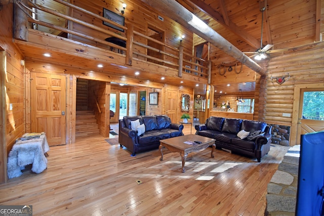 living room with ceiling fan, beamed ceiling, light hardwood / wood-style floors, and high vaulted ceiling