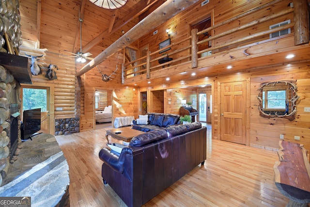 living room featuring light wood-type flooring, ceiling fan, beam ceiling, wood ceiling, and high vaulted ceiling