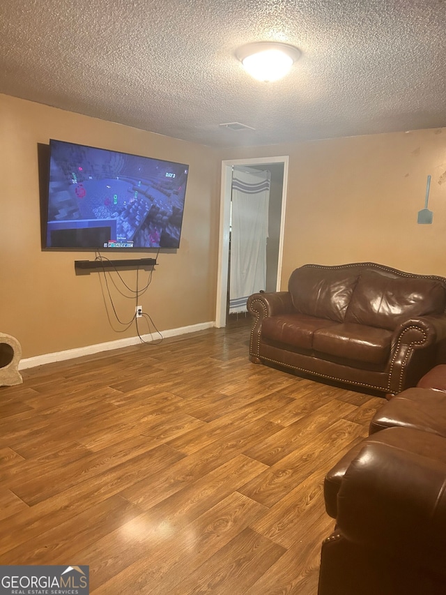 living room with a textured ceiling and hardwood / wood-style floors