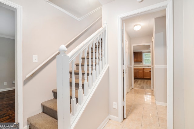 stairs featuring crown molding and hardwood / wood-style floors