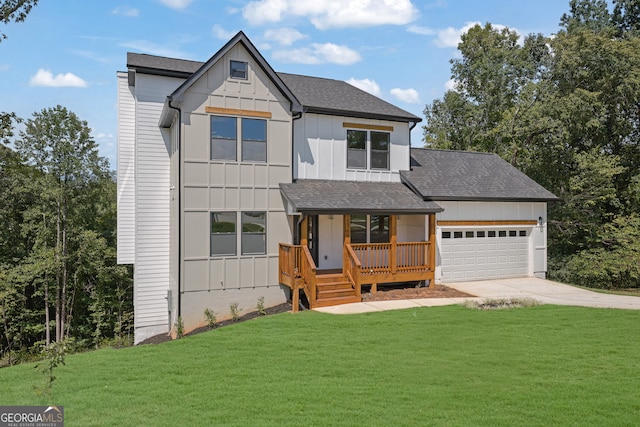 view of front of property featuring a garage, a front yard, and a porch