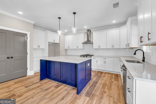 kitchen featuring wall chimney exhaust hood, sink, and white cabinets