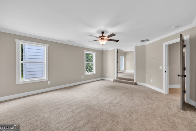 carpeted spare room featuring ceiling fan and crown molding