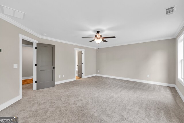 carpeted spare room with crown molding, a healthy amount of sunlight, and ceiling fan