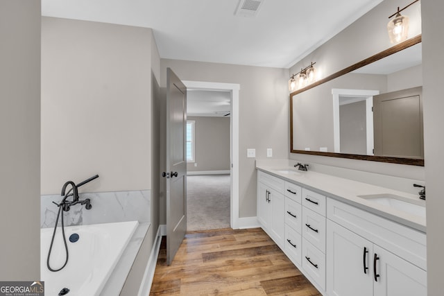 bathroom featuring vanity, hardwood / wood-style flooring, and a washtub