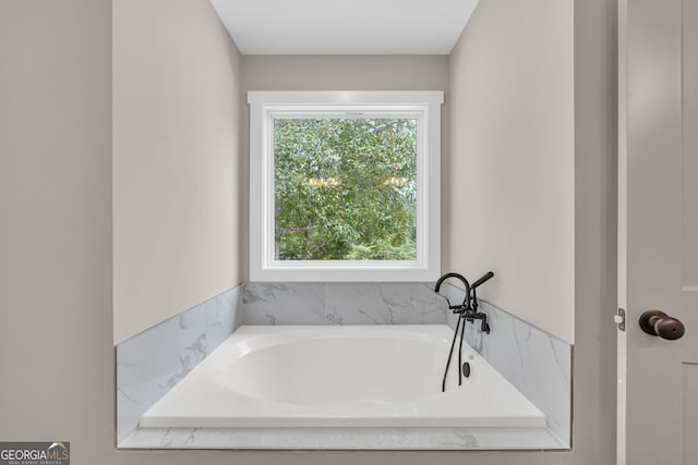 bathroom with a relaxing tiled tub