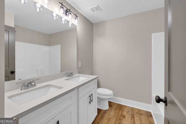 bathroom with toilet, hardwood / wood-style flooring, and vanity