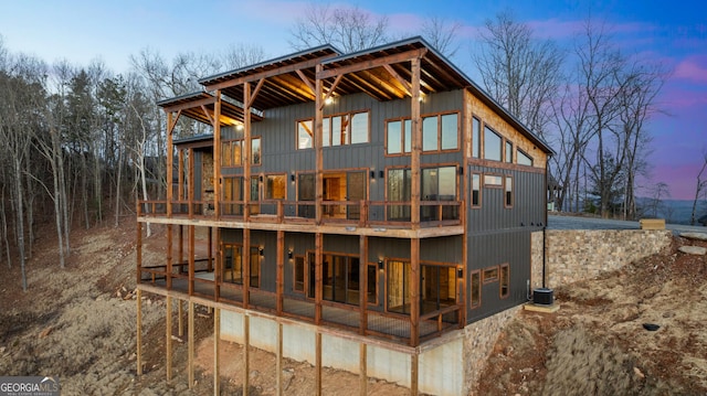 back house at dusk featuring central AC