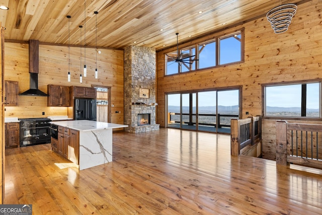 kitchen featuring black fridge, decorative light fixtures, a center island, a mountain view, and high quality range