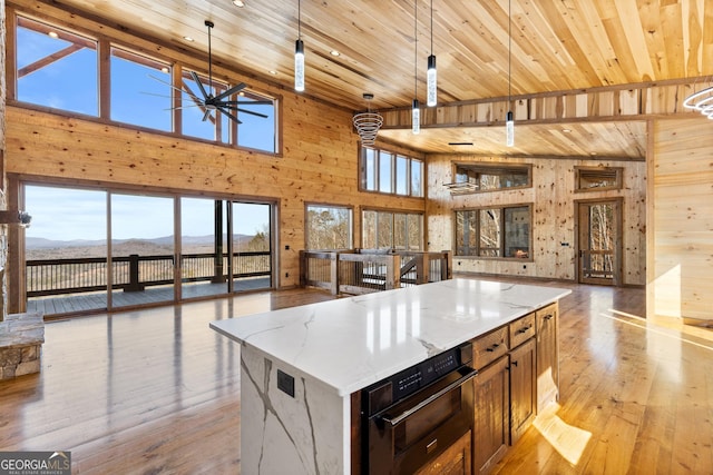 kitchen with a large island, decorative light fixtures, a mountain view, and light stone countertops