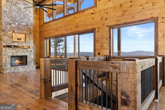 interior space with wood-type flooring, a fireplace, a mountain view, and wood walls