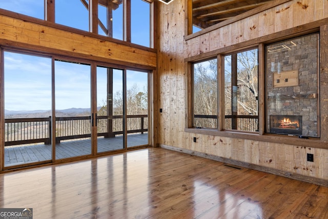 unfurnished sunroom featuring a mountain view and a stone fireplace