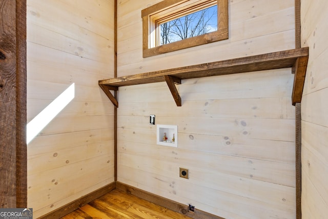 laundry room featuring wood-type flooring, wooden walls, hookup for a washing machine, and electric dryer hookup