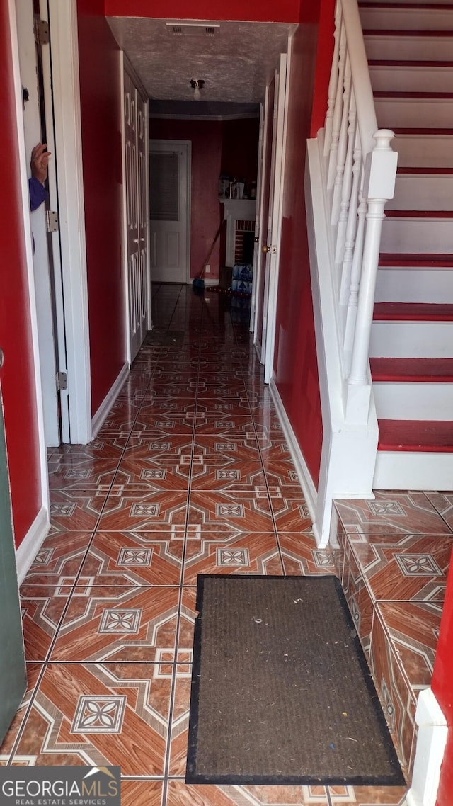 hall with dark tile patterned flooring