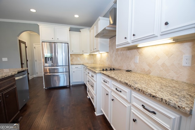 kitchen featuring appliances with stainless steel finishes, dark hardwood / wood-style flooring, wall chimney exhaust hood, crown molding, and white cabinets