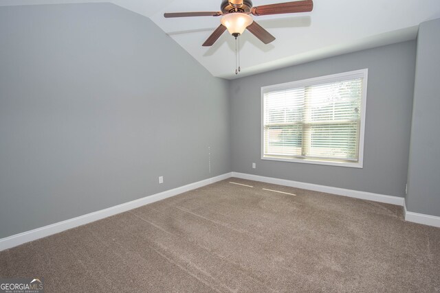 empty room featuring ceiling fan, carpet, and vaulted ceiling