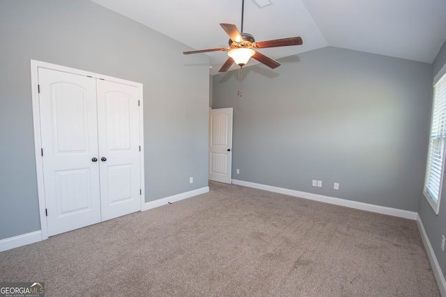 unfurnished bedroom featuring carpet flooring, ceiling fan, a closet, and vaulted ceiling