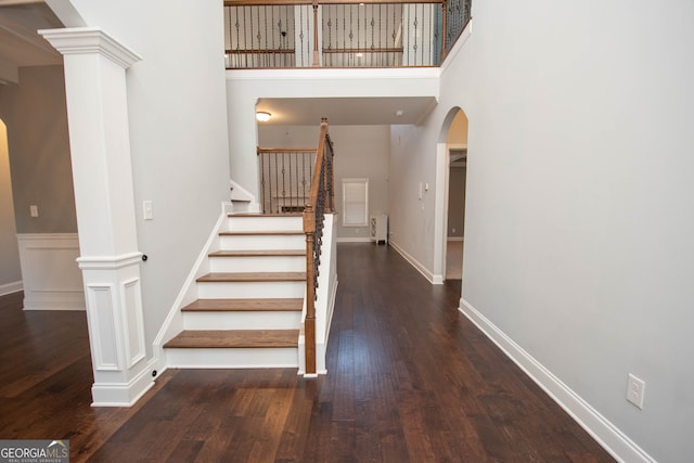 staircase featuring hardwood / wood-style flooring and a high ceiling