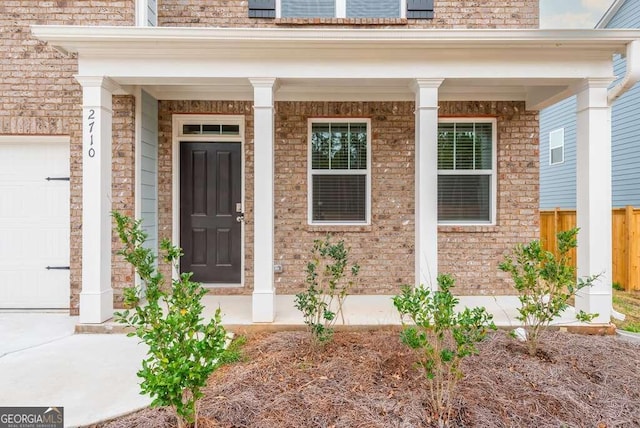 doorway to property featuring a porch and a garage