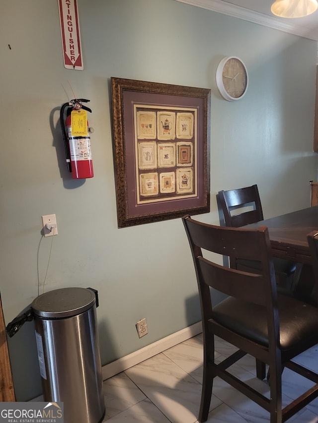 dining space featuring crown molding and light tile patterned floors