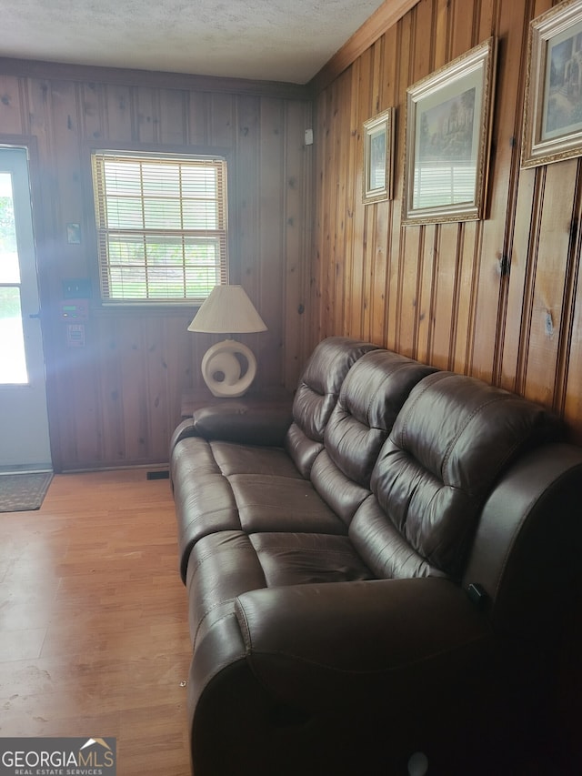 living room featuring light wood-type flooring and wooden walls