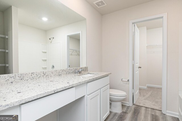 full bathroom featuring hardwood / wood-style flooring, shower with separate bathtub, toilet, and vanity