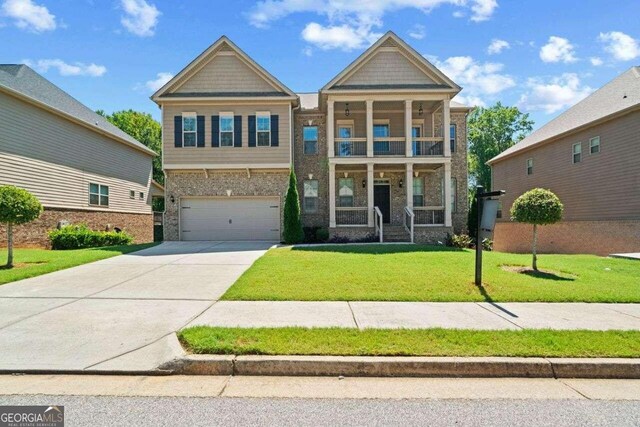 craftsman house featuring a front lawn, a garage, and a balcony