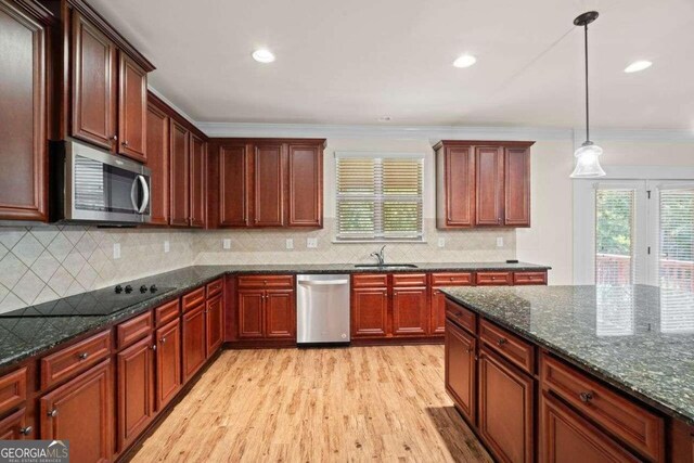 kitchen featuring ornamental molding, stainless steel appliances, tasteful backsplash, and light hardwood / wood-style flooring