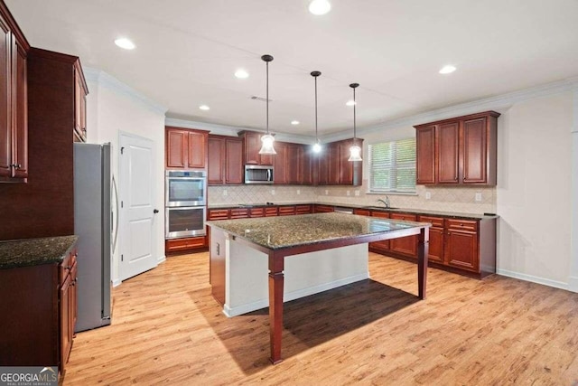 kitchen with a kitchen island, appliances with stainless steel finishes, decorative backsplash, and light hardwood / wood-style floors