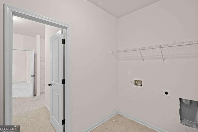 clothes washing area with washer hookup, light colored carpet, and electric dryer hookup